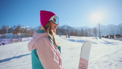 Woman Snowboarding in the Mountains on Sunny Day