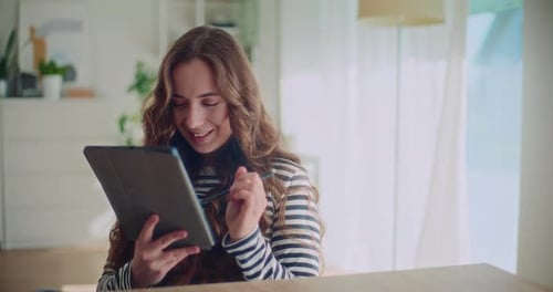 Young Adult Woman Uses Tablet and Stylus at Home