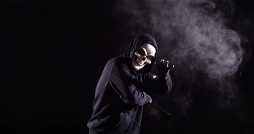 Grim Reaper Figure with Knife in Smoky Darkness