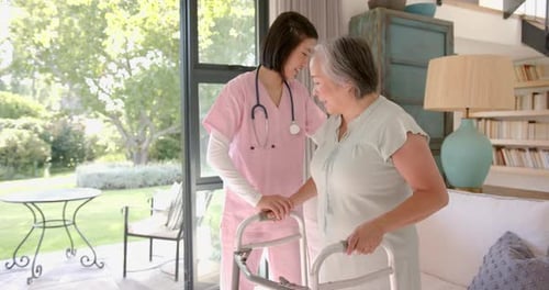 Adult Helping Senior with Walker at Home