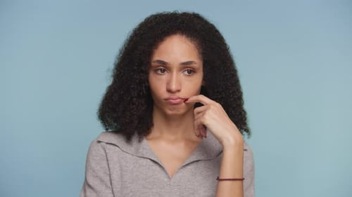 Thoughtful Young Woman Smiling with Hand on Face