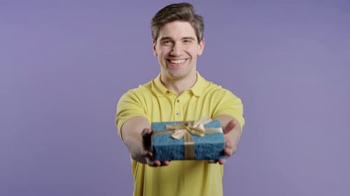 Man Holds Out Gift Box for Birthday Celebration