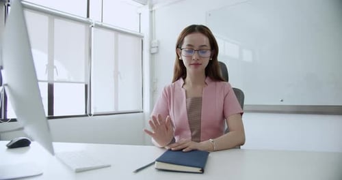 A focused worker engages in tasks at her desk in a modern office exemplifying productivity.