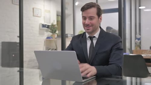 Man in Suit on Video Call in Modern Office