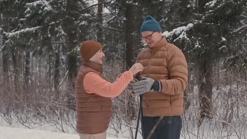 Active Senior Couple Nordic Walking in Winter Forest
