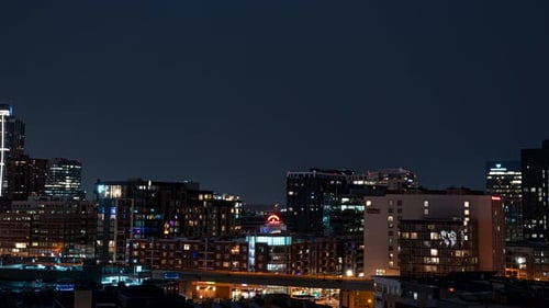 Lightning storm over Denver city skyline illuminates night sky. Timelapse
