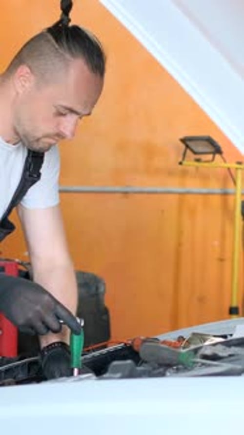 A Mechanic Repairs a White Car He Inspects the Car's Engine Car Repair Service Vertical Video