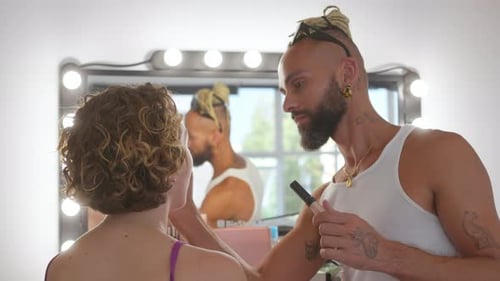 Gay Man Applying Makeup on Woman in Studio