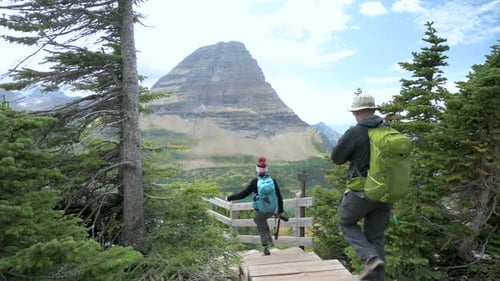 Couple walking up to the Hidden Lake Overlook and viewing Hidden Lake in Glacier National Park, stat