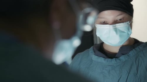 Dois médicos durante um procedimento cirúrgico na sala de cirurgia
