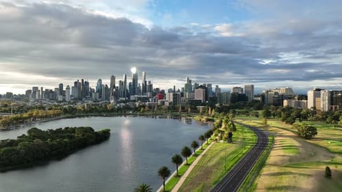 Stunning Aerial City Skyline Reflects in Lake Beside Beautiful Green Park