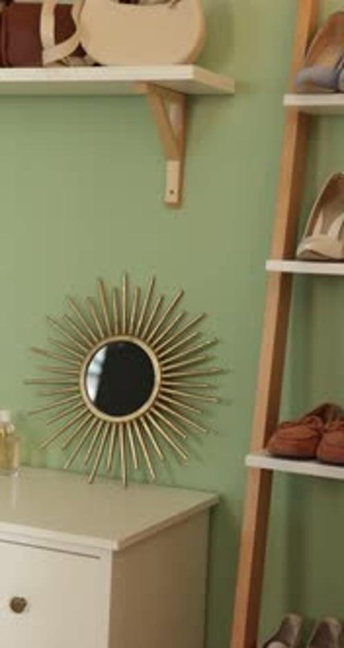 Étagère avec vêtements, chaussures sur étagère et commode dans le couloir. La caméra se déplace vers la gauche