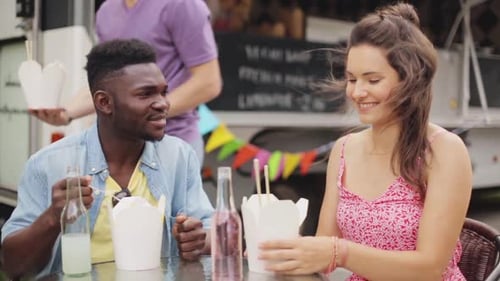 Friends Enjoying Takeout Near a Food Truck