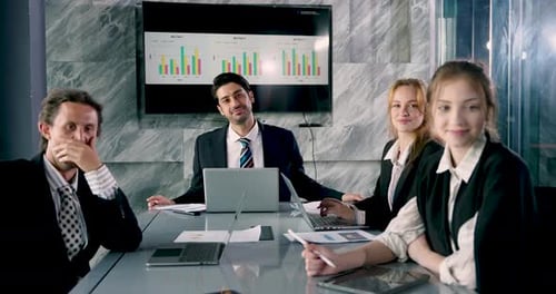 Business Team Meeting Around Conference Table with Laptops