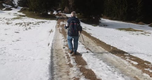 Man Hiking on Snowy Mountain Trail in Winter