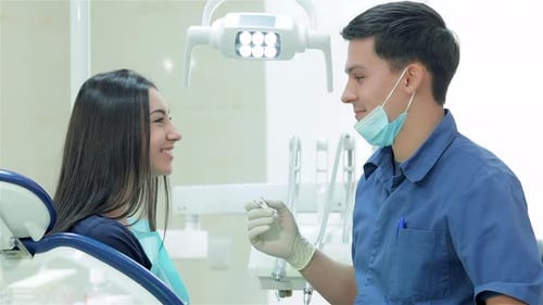 Dentist Consults with a Woman Patient in Clinic