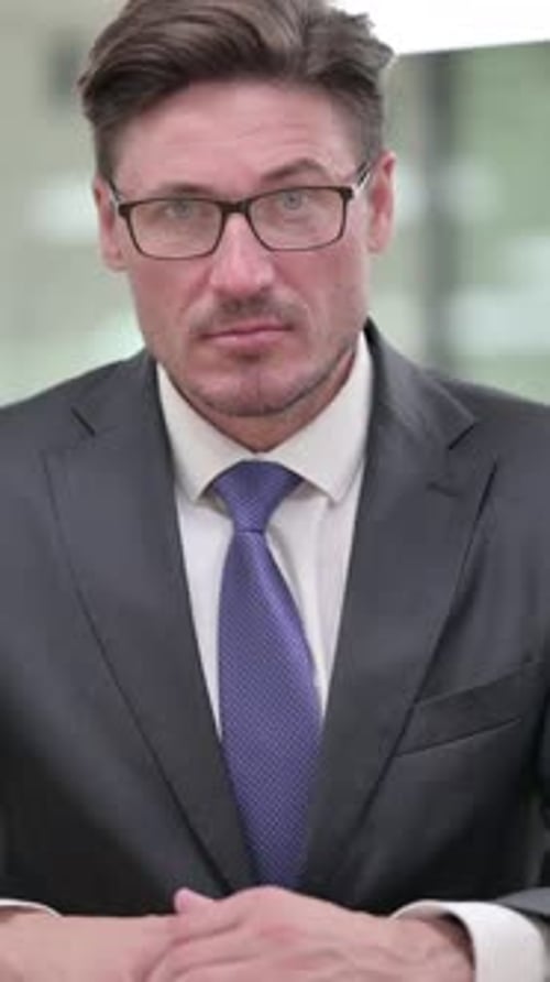 Serious Man in Suit Raising Index Finger