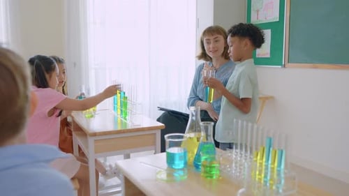 Adorable student learn with teacher in classroom at elementary school.