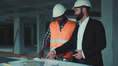 Architects Reviewing Blueprints on Construction Site