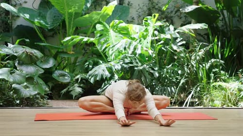 Woman in graceful meditation pose in green garden