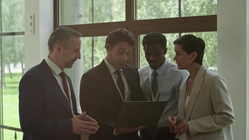 Business Team Collaborates on Laptop in Bright Office