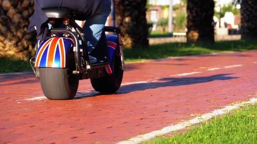 Personnes conduisant une trottinette électrique sur une piste cyclable dans le parc Ralentissement