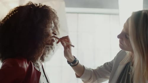 Woman Having Makeup Applied by Makeup Artist