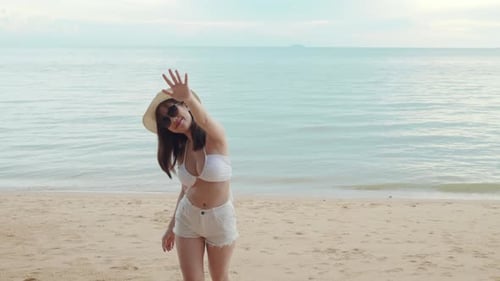 Beautiful Asian Woman Wear Sungrass and Hat Turning Back Running to Beach