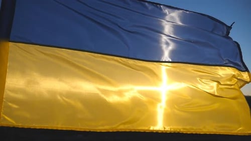 Ukrainian Flag Waving Against the Sky at Sunrise