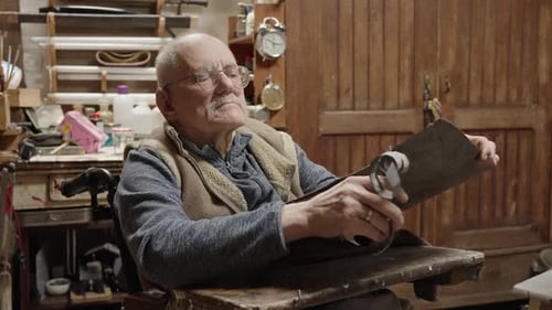 Senior Elderly Master Jeweler in Wheelchair Works in a Workshop