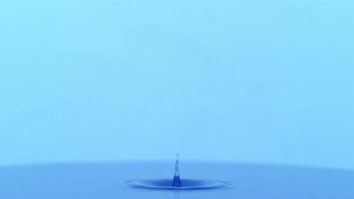 Water Drop Impacting Surface Creating Circular Ripples