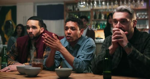 Man, friends and celebration at sports bar with fist pump, game and hug with drinks at social event