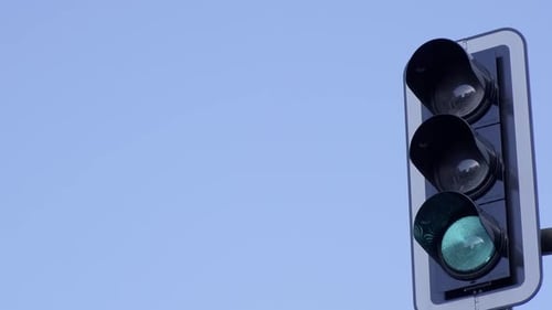A Cityscape Features Traffic Lights Changing From Green to Red