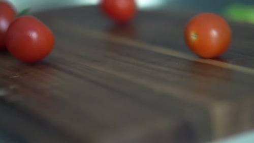 Close Up of Cherry Tomatoes Falling and Rolling on Wooden Board, Super