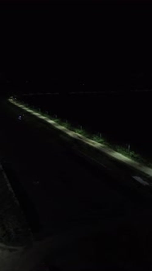 Vertical drone footage of deserted street at night
