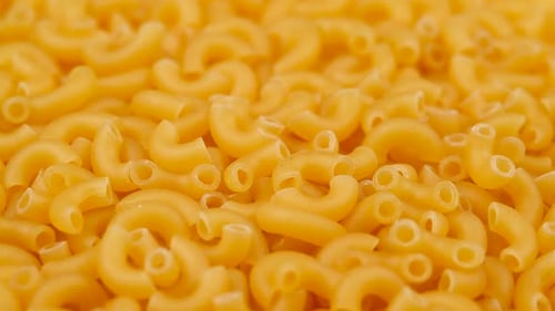 Background Of Chifferi Rigati Pasta. Uncooked Italian Pasta Golden Rotating Backdrop. Healthy Eating