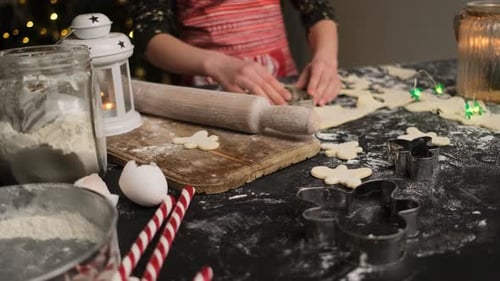 Person Making Christmas Cookies With Cookie Cutters