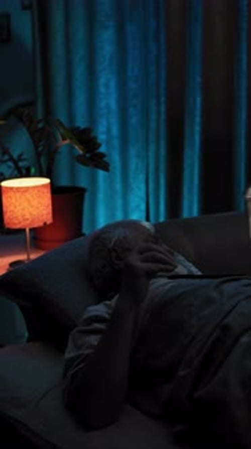 At Nigh Man in Bed Turn on Night Lamp Take on Glasses and Start Looking Phone
