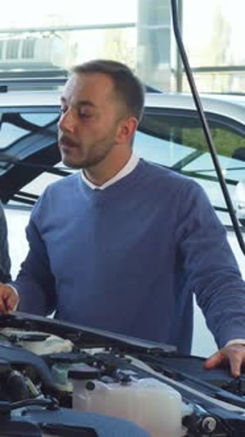 Buyer and Seller Engaged in a Detailed Discussion Over a Car's Engine