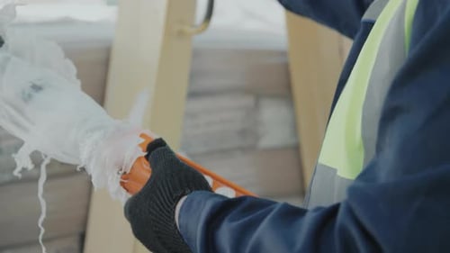 Trabalhador de fábrica irreconhecível usando guincho de elevação