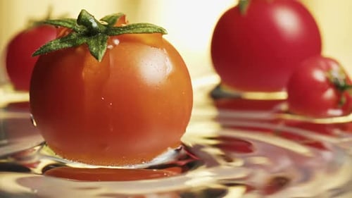 Kleine Kirschtomaten im Wasser, Wassertropfen, Zeitlupe, Makro,