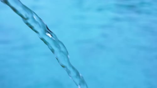 Water Pouring Into a Bright Blue Swimming Pool