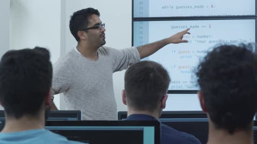 Lehrer spricht in der Vorlesung im Computerunterricht über Programmieren