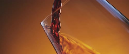 Dark Red Liquid Pouring Into Clear Glass