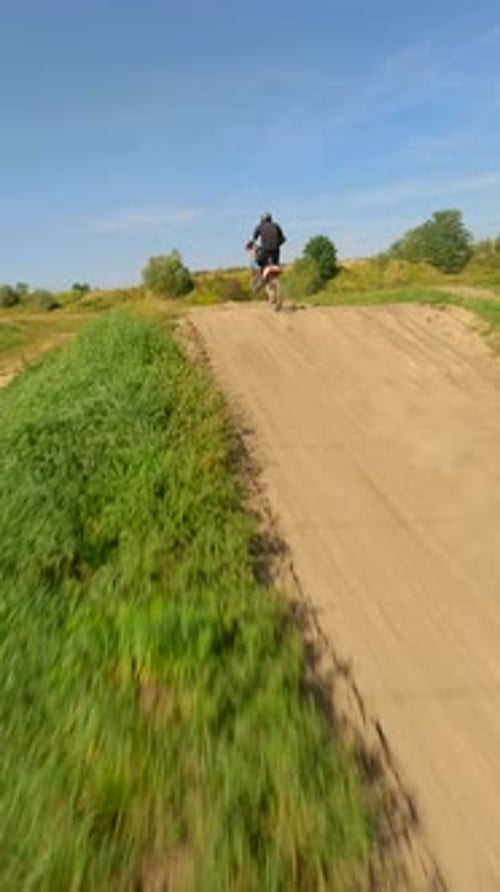 Dirt Bike Rider Jumping Ramps on Rural Course