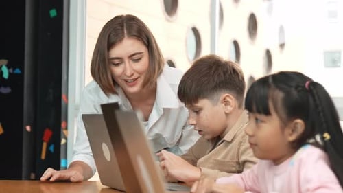 Der Lehrer überprüft die Antwort des Schülers, während der Lernende den Laptop benutzt. Seitenansicht. Gelehrsamkeit
.
