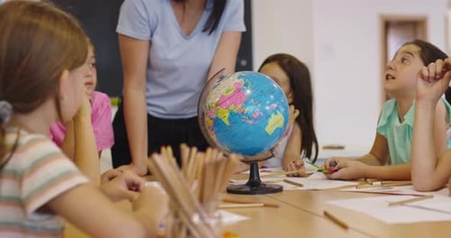 Lehrer und Grundschüler lernen Geografie mit Globus im Klassenzimmer Neugierige Kinder