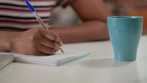 Close Up of Person Writing in Notebook