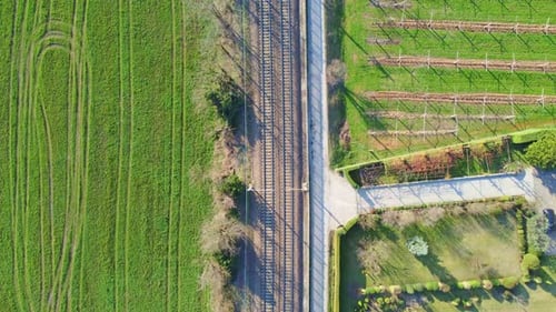 Bird's Eye View of Railway Tracks Between Lush Green Fields