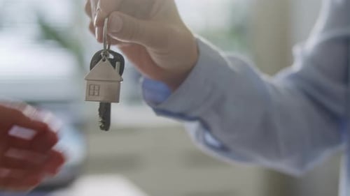 Close Up of Real Estate Agent Handing over House Key to Homeowner